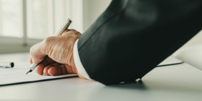 Businessman signing a contract on his desk