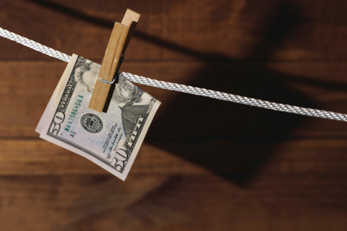 US dollar banknote is hung on a rope with clothespin