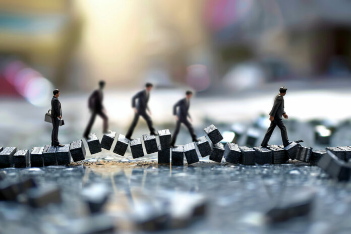 figurine-miniatura-che-si-arrampicano-su-blocchi-che-simboleggiano-la-leadership-il-lavoro-di-squadra-e-il-successo