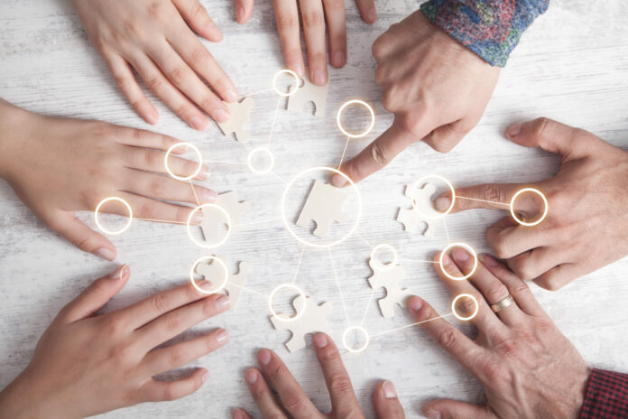 Hands of people holding jigsaw puzzle Connection Partnership